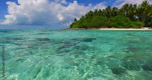 Pull back shot of an amazing landscape in Thailand with crystal clear water, palm trees on the island and a dramatic sky in the distance 4K photo