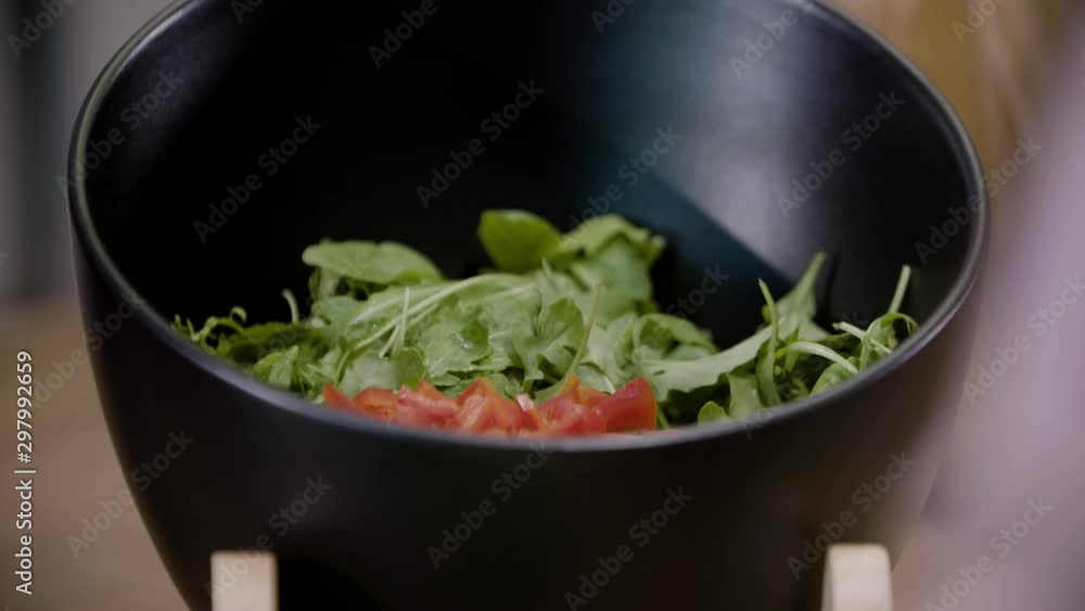 Close up of home cooking with the family. Woman's hands mixing inside a salad bowl Close up of home cooking with the family. Woman's hands mixing inside a salad bowl