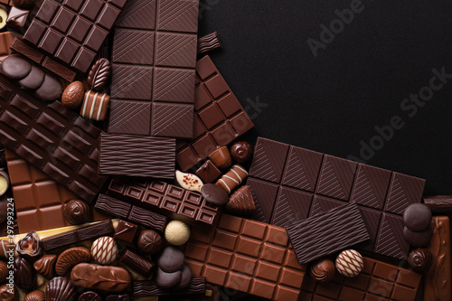 dark chocolate background, sweet bar and candy with empty space for text