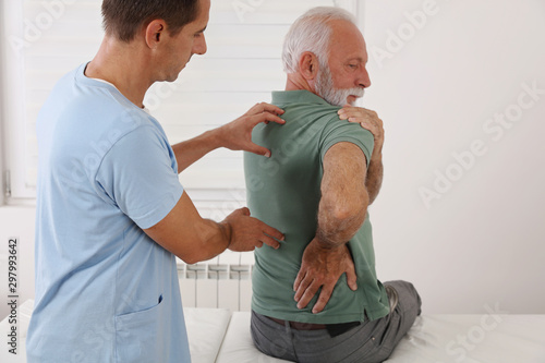 Senior man with back pain. Spine physical therapist and paient. chiropractic pain relief therapy. Age related backache photo