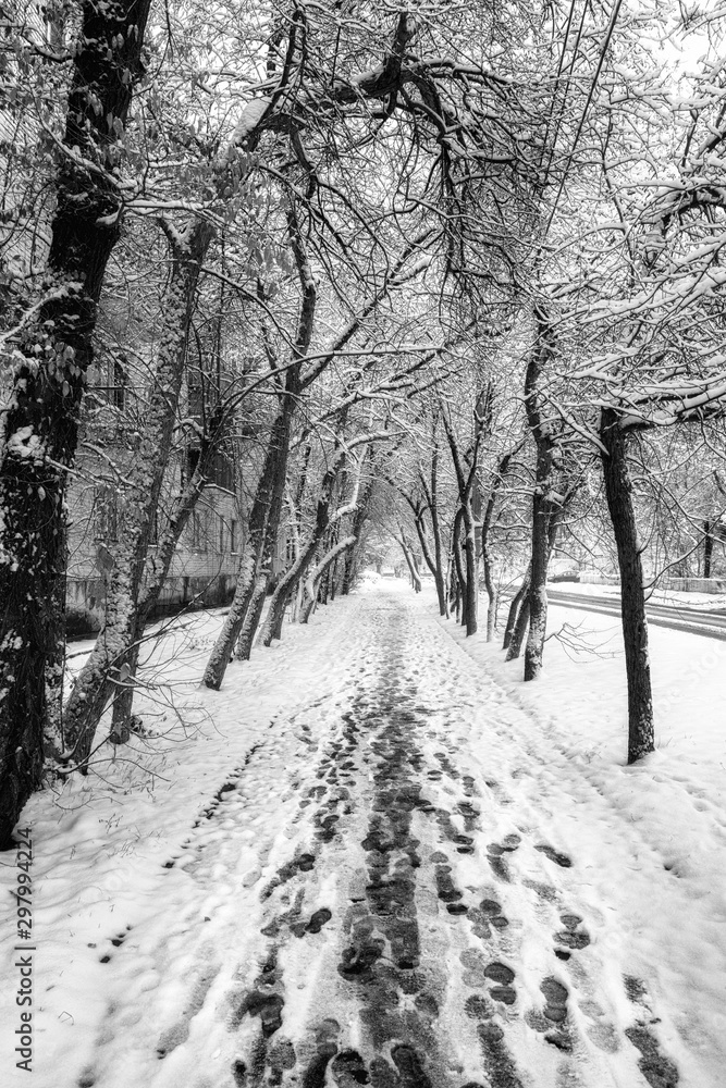 snow-covered alley in the city with footprints in the snow snow-covered alley in the city with footprints in the snow