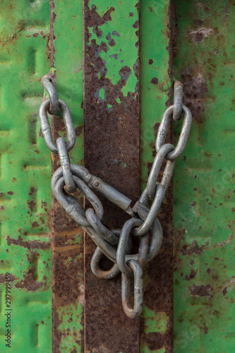 Closed lock with a chain on an old metal door