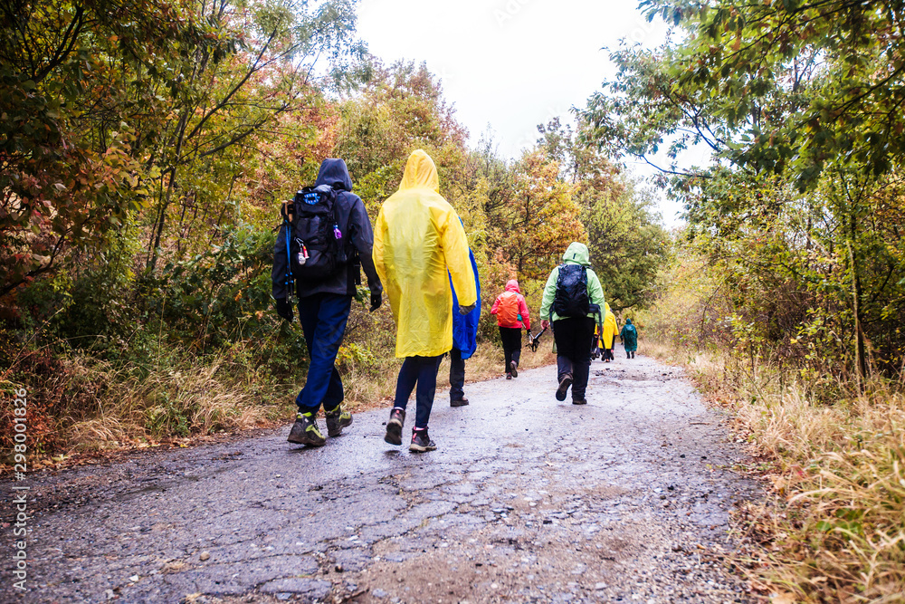 Rearview of unrecognizable people hiking on a rainy day in nature Rearview of unrecognizable people hiking on a rainy day in nature