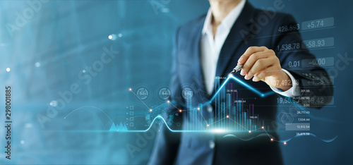 Businessman draw growth graph and progress of business and analyzing financial and investment data ,business planning and strategy on blue background. photo