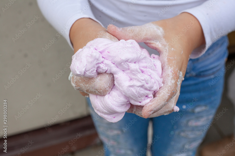 Sticky slime in the hand. The child wrinkles slime in his hands. Favorite toy for a child. Do-it-yourself starch soft, pleasant to the touch anti-stress trainer.