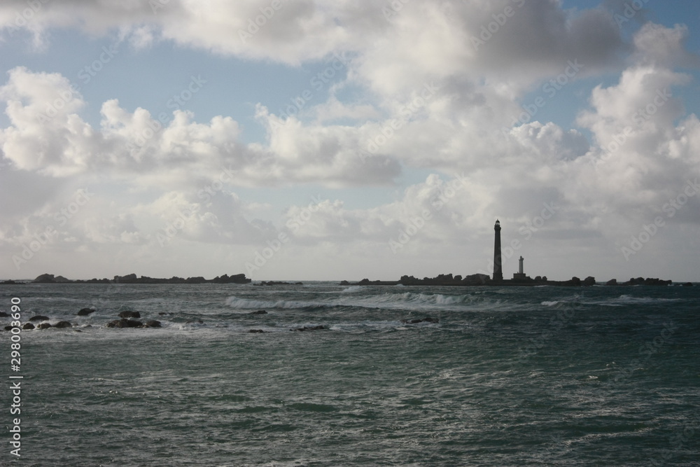 Deux phares sur une île se dressent au milieu des vagues d'une tempête