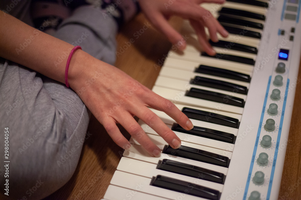 Piano playing. The girl’s hands are sorting the keys. Game on the host at home. Music lessons. Classes at the piano. Modern music.