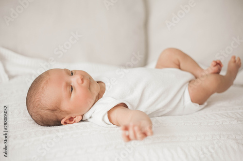 Little cute newborn is lying on the bed. Baby.
