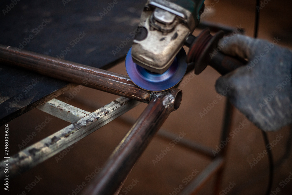 Cutting and grinding metal in the workshop. Work with a metal profile. Sparks from the work of a grinder for metal. Cutting and grinding metal in the workshop. Work with a metal profile. Sparks from the work of a grinder for metal.