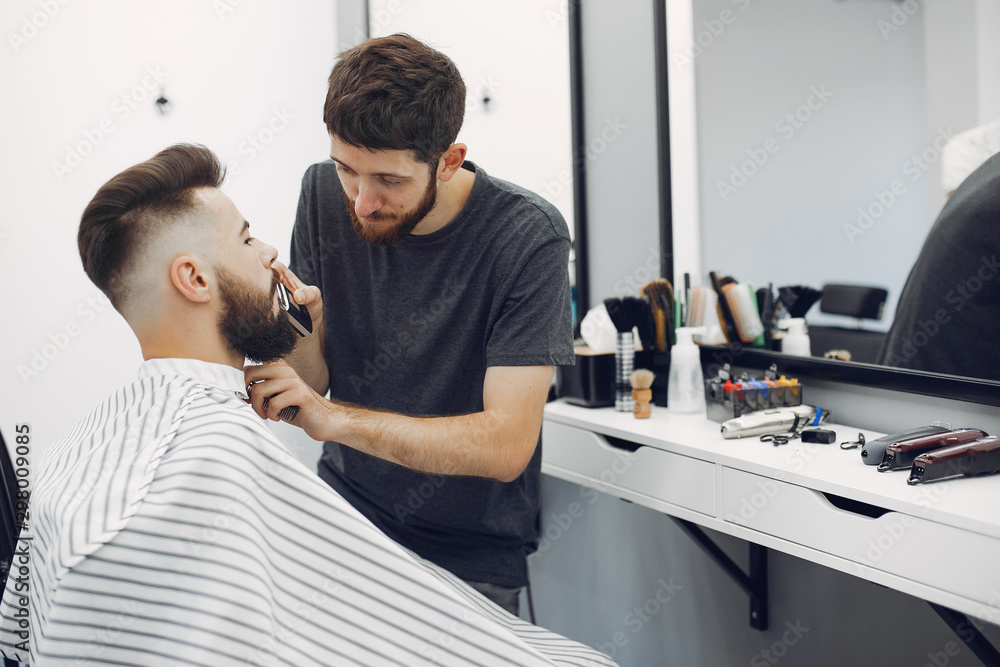 Man with a beard. Hairdresser with a client. Brunette in a barbershop Man with a beard. Hairdresser with a client. Brunette in a barbershop