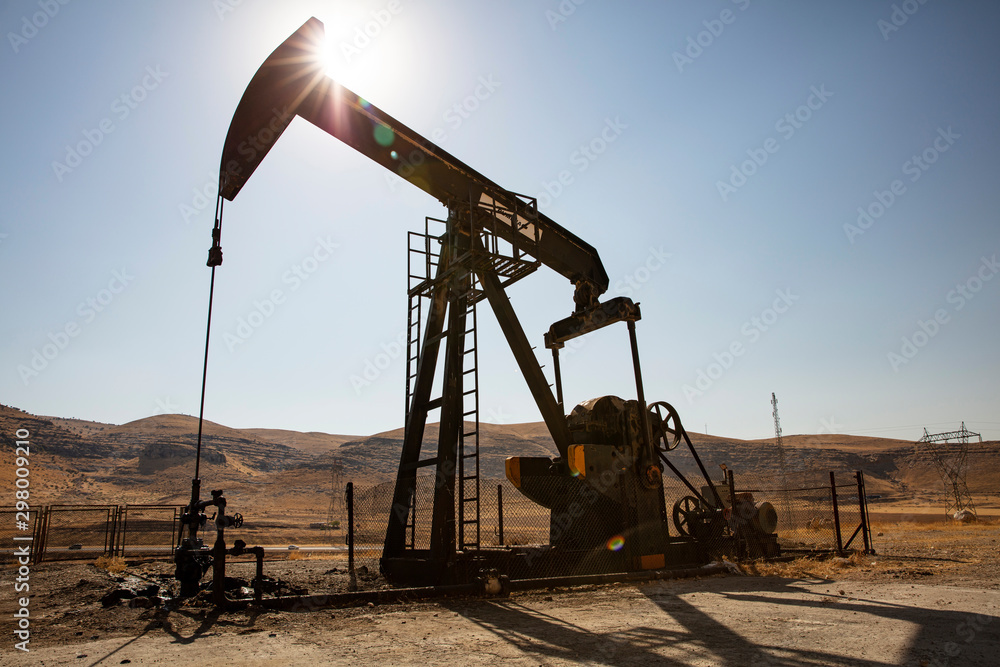 Oil drilling derricks at desert oilfield. Crude oil production from the ground. Oilfield services contractor. Oil drill rig and pump jack. Petroleum production, natural gas, liquids, NGL, additive. Oil drilling derricks at desert oilfield. Crude oil production from the ground. Oilfield services contractor. Oil drill rig and pump jack. Petroleum production, natural gas, liquids, NGL, additive.