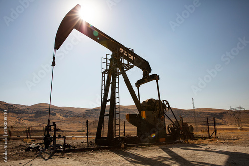 Oil drilling derricks at desert oilfield. Crude oil production from the ground. Oilfield services contractor. Oil drill rig and pump jack. Petroleum production, natural gas, liquids, NGL, additive. photo