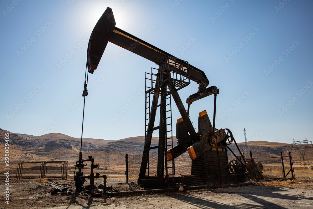 Oil drilling derricks at desert oilfield. Crude oil production from the