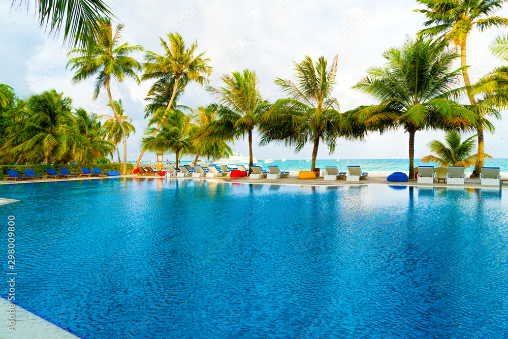 Fototapeta premium Private oceanfront pool with submerged loungers in a luxury reso