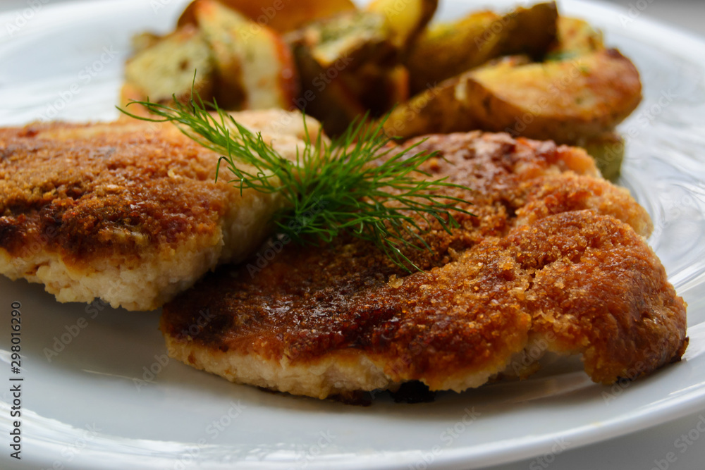 Schnitzel with wedges patoto on white background. Close up Schnitzel with wedges patoto on white background. Close up