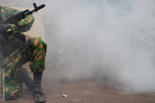 The soldier is preparing to attack. The smoke of war and the military awaits directions. Machine gun barrel at war. Demonstration performance of the military.
