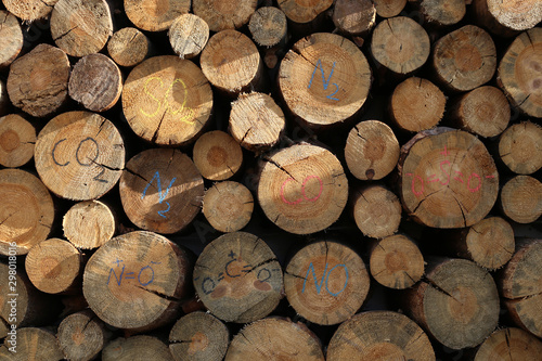 Chunks of pine firewood  in storage  with colored inscriptions of the formulas of gases  products of the combustion of firewood.