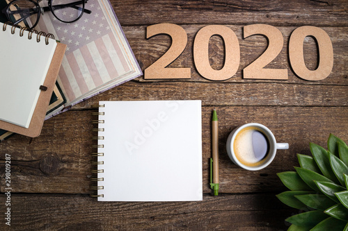 Office desk table with notebooks, coffee cup, american flag. New year 2020 resolutions or goals list. Goal, plan, strategy, politics, international relations, economics, american history concept photo