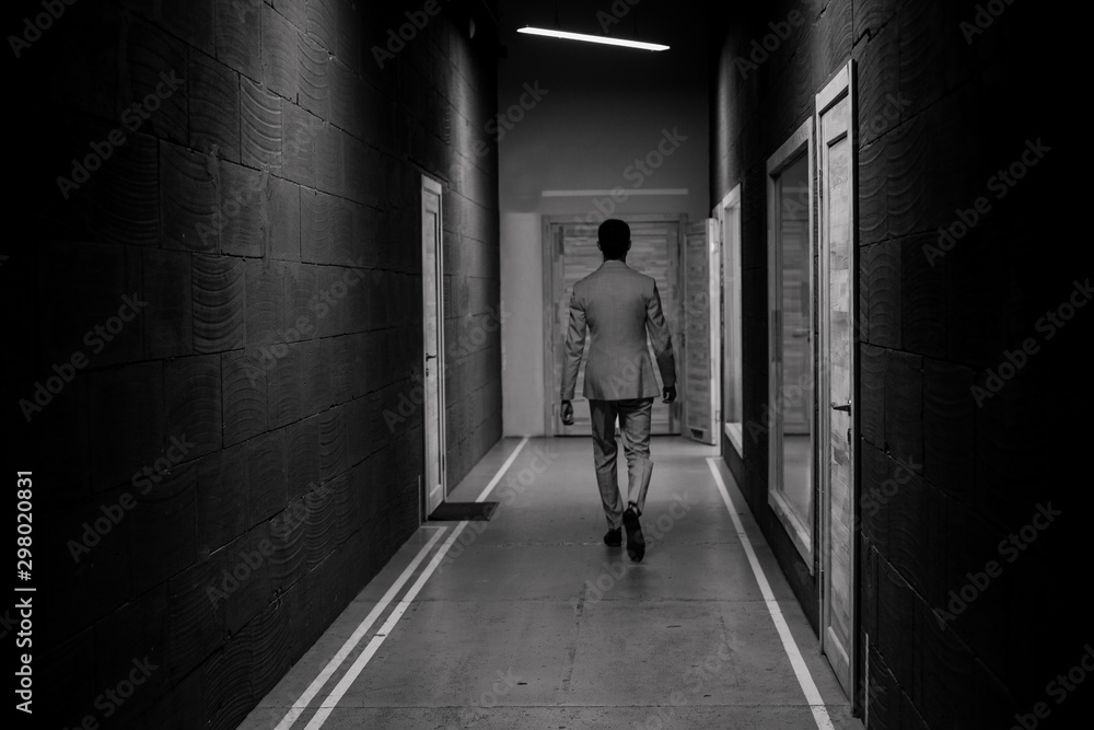 successful man walks down corridor chooses door
