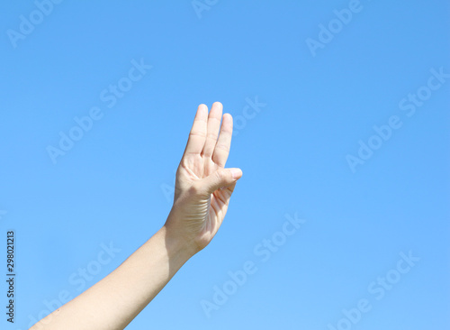 woman hand on blue sky background