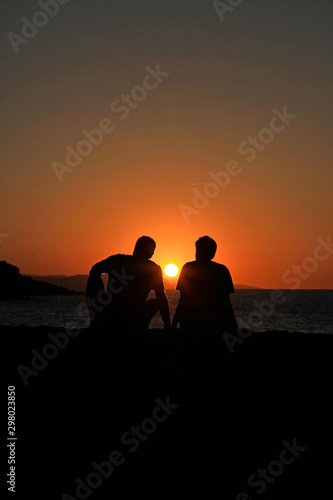 pareja de hombres sentados viendo el atardecer en el mar IMG_9261-as19 photo