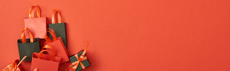 Top view of gift boxes and shopping bags on red background with copy space, panoramic shot