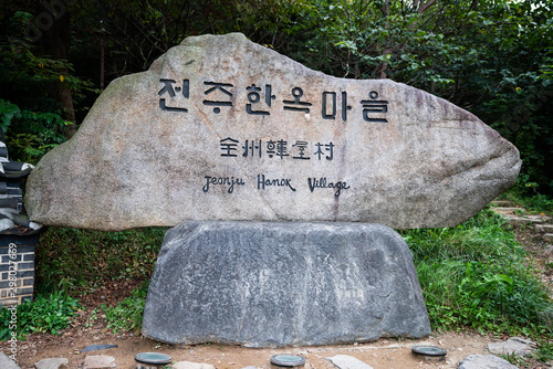 Rock sign at the entrance of Jeonju Hanok village district with name written in Korean and English in South Korea photo