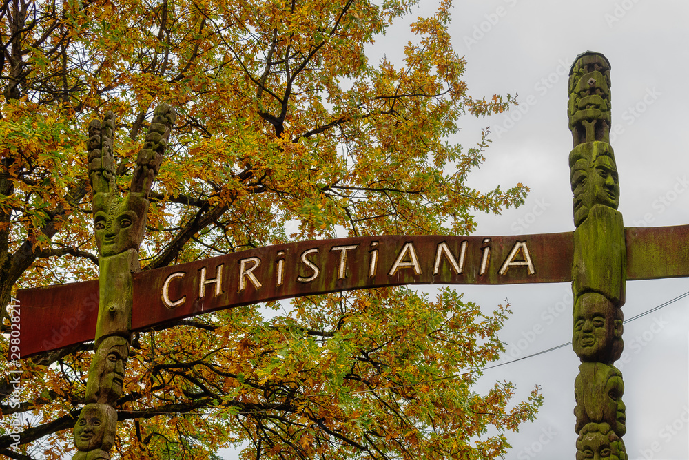 Φωτογραφία A sign between two totem poles to the freetown Christiania in Copenhagen