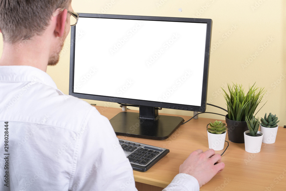 Office worker at the workplace at the computer with copy space on the monitor.Looking at Something on the Computer Screen Office worker at the workplace at the computer with copy space on the monitor.Looking at Something on the Computer Screen