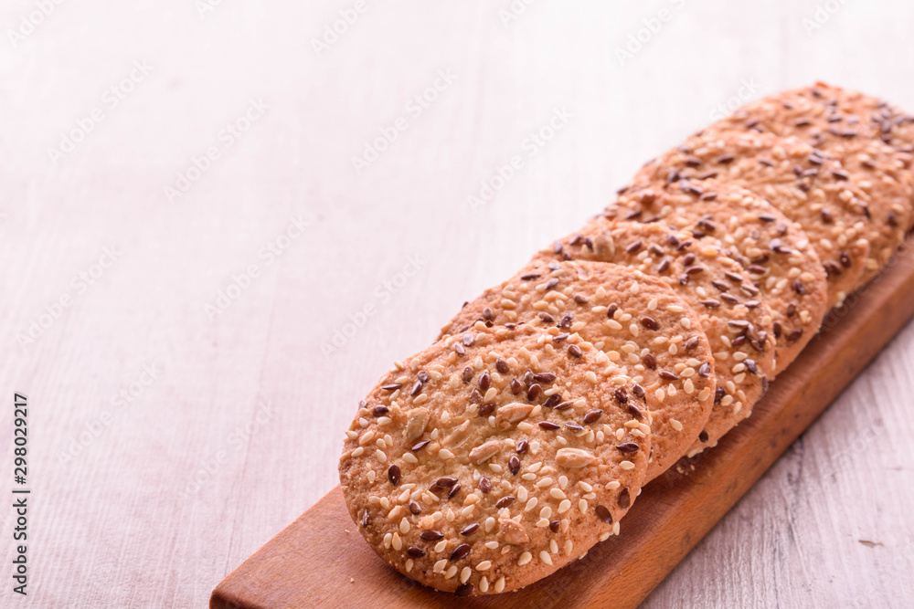 Φωτογραφία Cookies of sesame seeds, sunflower seeds and other spices on a wooden plate