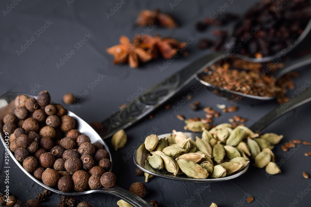 Various spices spoons on stone table.On dark concrete background.Herbs and spices on wooden table. Top view with space for your text Various spices spoons on stone table.On dark concrete background.Herbs and spices on wooden table. Top view with space for your text