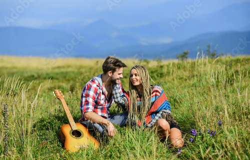 Never boring. friendship. campfire songs. men play guitar for girl. couple in love spend free time together. happy friends with guitar. western camping. hiking. country music. romantic date photo