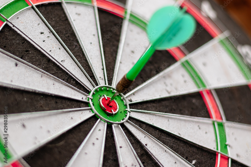 Green arrow in the center of the dart board Shows the concept of business goal setting. Green arrow in the center of the dart board Shows the concept of business goal setting.