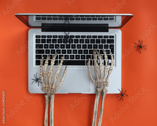 Skeleton hands typing on laptop