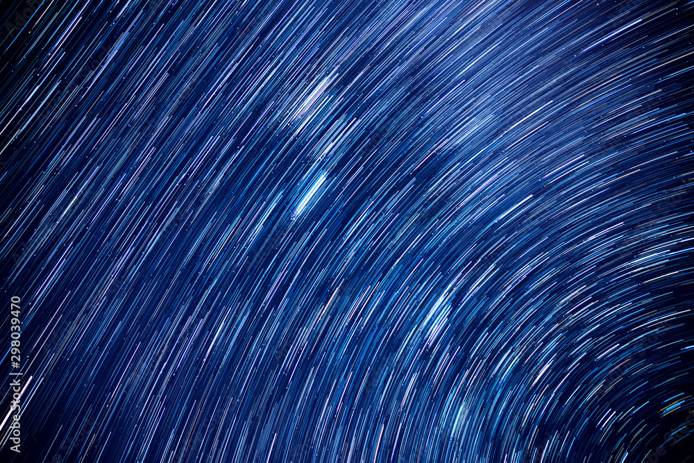 Star trails movement at night.Abstract long exposure of strail trails against a blue sky at dark night. Star trails movement at night.Abstract long exposure of strail trails against a blue sky at dark night.