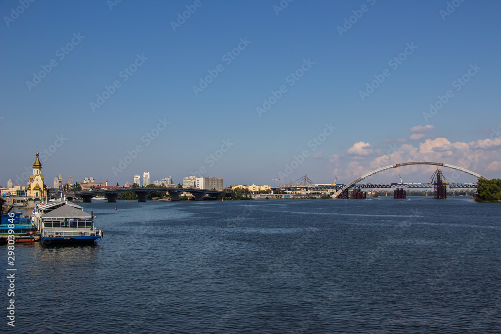Obraz premium Tour of Kiev in the center of Europe. View of the Dnieper, Trukhanov island and a foot bridge. Park fountain and sunset on the horizon..