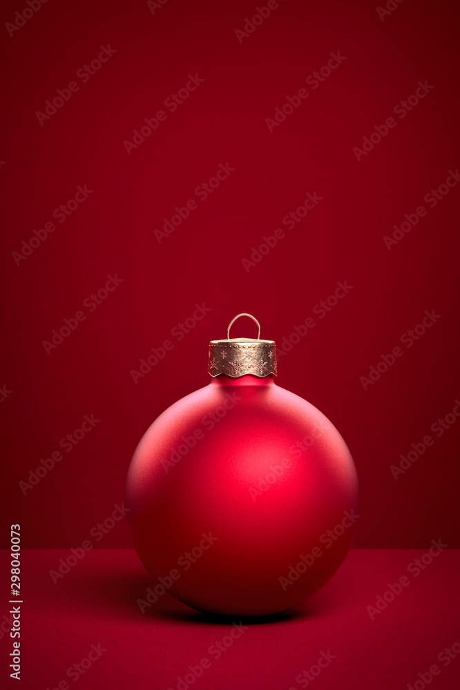 Red christmas ball standing on red background Red christmas ball standing on red background