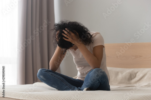 Depressed black girl sit on bed having life problems © fizkes