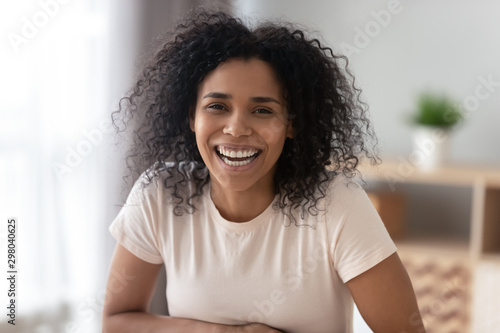 Portrait of smiling black millennial girl posing at home