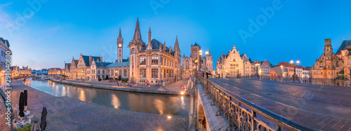 Panoramic view of the Graslei, quay in the promenade next to river Lys in Ghent, Belgium and St Michael's Bridge at dusk. Gent old town is famous for its beautiful illuminated buildings and landmarks