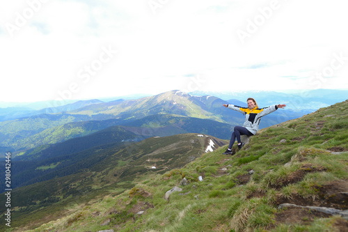 Young free female tourist wearing yellow jacket sitting in Appenine mountains. photo