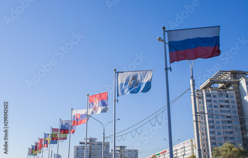 Flags fluttering in the wind against a blue sky.