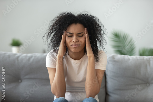 Exhausted black woman massage head suffering from migraine photo