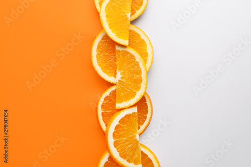 Slices of fresh orange fruit on color background