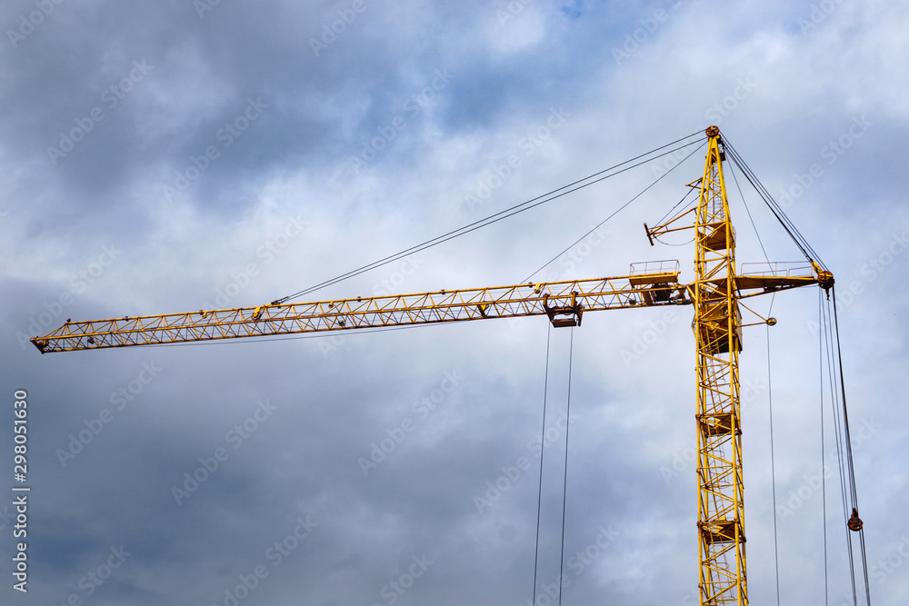 construction of houses on a cloudy day construction crane on the streets of the city