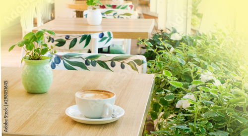 white cup with coffee on the table, in the morning, in a cafe on a bright veranda, close-up, selective focus, soft bluer.