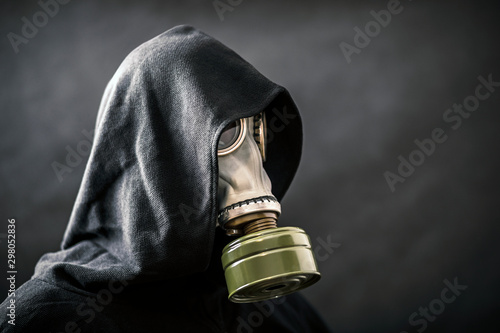 Man in a gas mask and hooded cloak. Environment pollution. photo