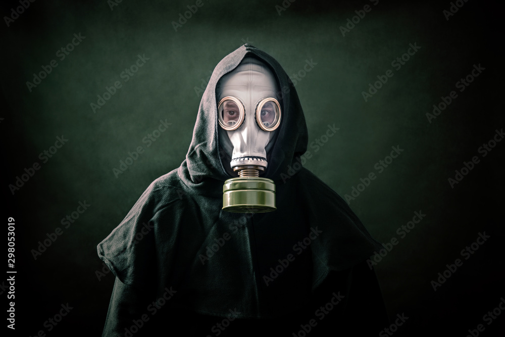 Man in a gas mask and hooded cloak. Environment pollution.