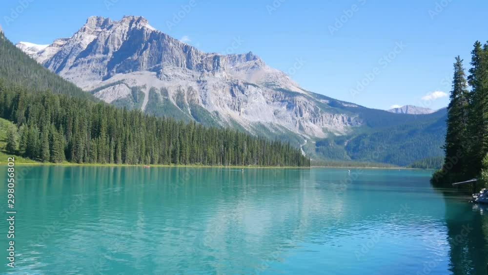 Landscape natural view of the emerald lake with in Banff Alberta Canada with clear green lake water and pine tree forest and mountain in the background in summer sunshine day Landscape natural view of the emerald lake with in Banff Alberta Canada with clear green lake water and pine tree forest and mountain in the background in summer sunshine day