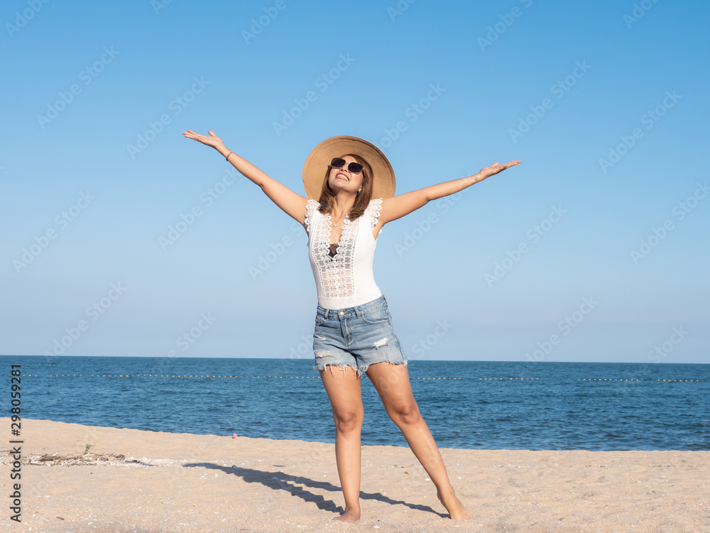Happy Asian woman enjoying on the beach with straw hat in sunny day, lifestyle concept. Happy Asian woman enjoying on the beach with straw hat in sunny day, lifestyle concept.